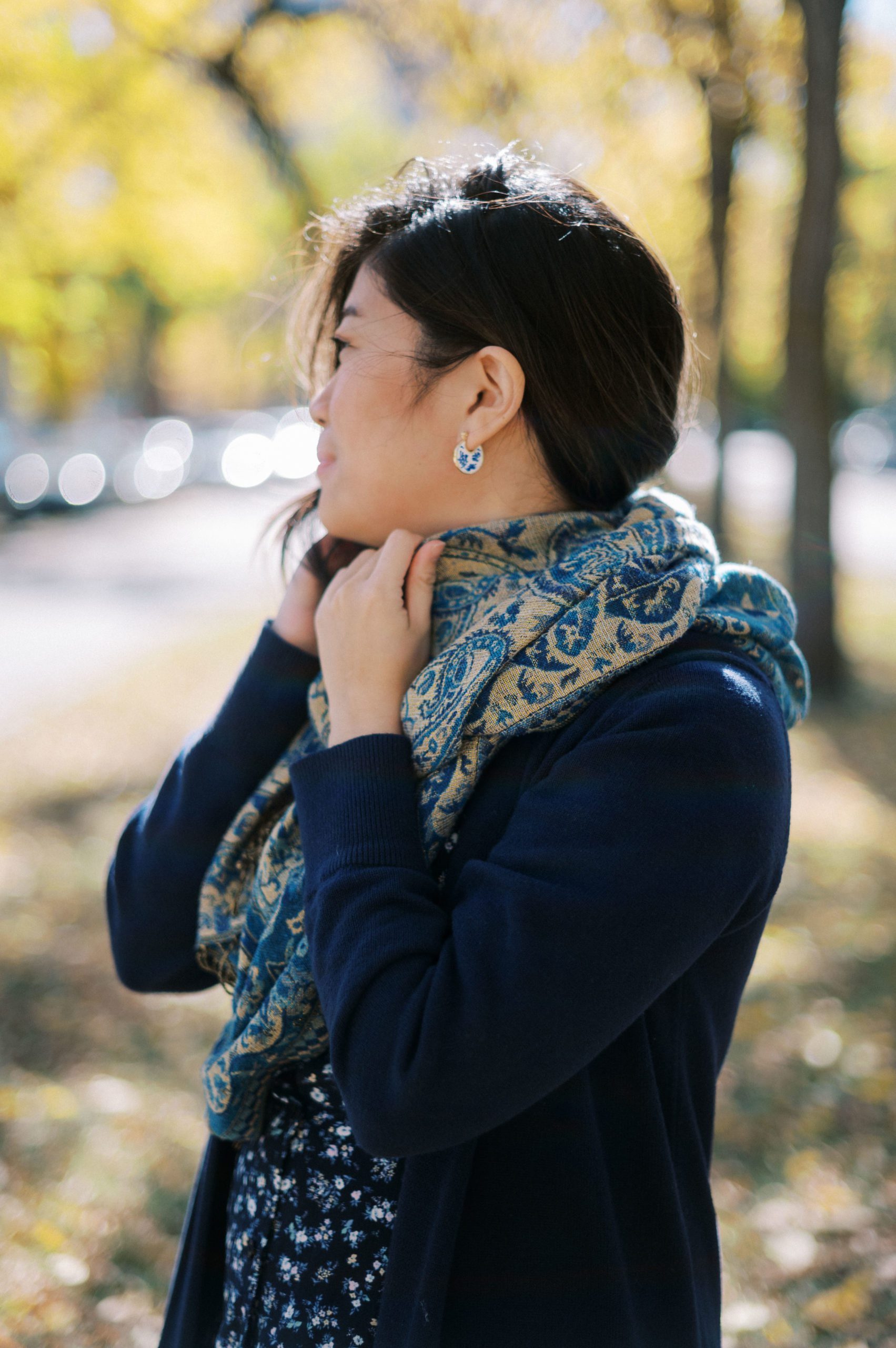 Woman holding blue scarf up to her neck