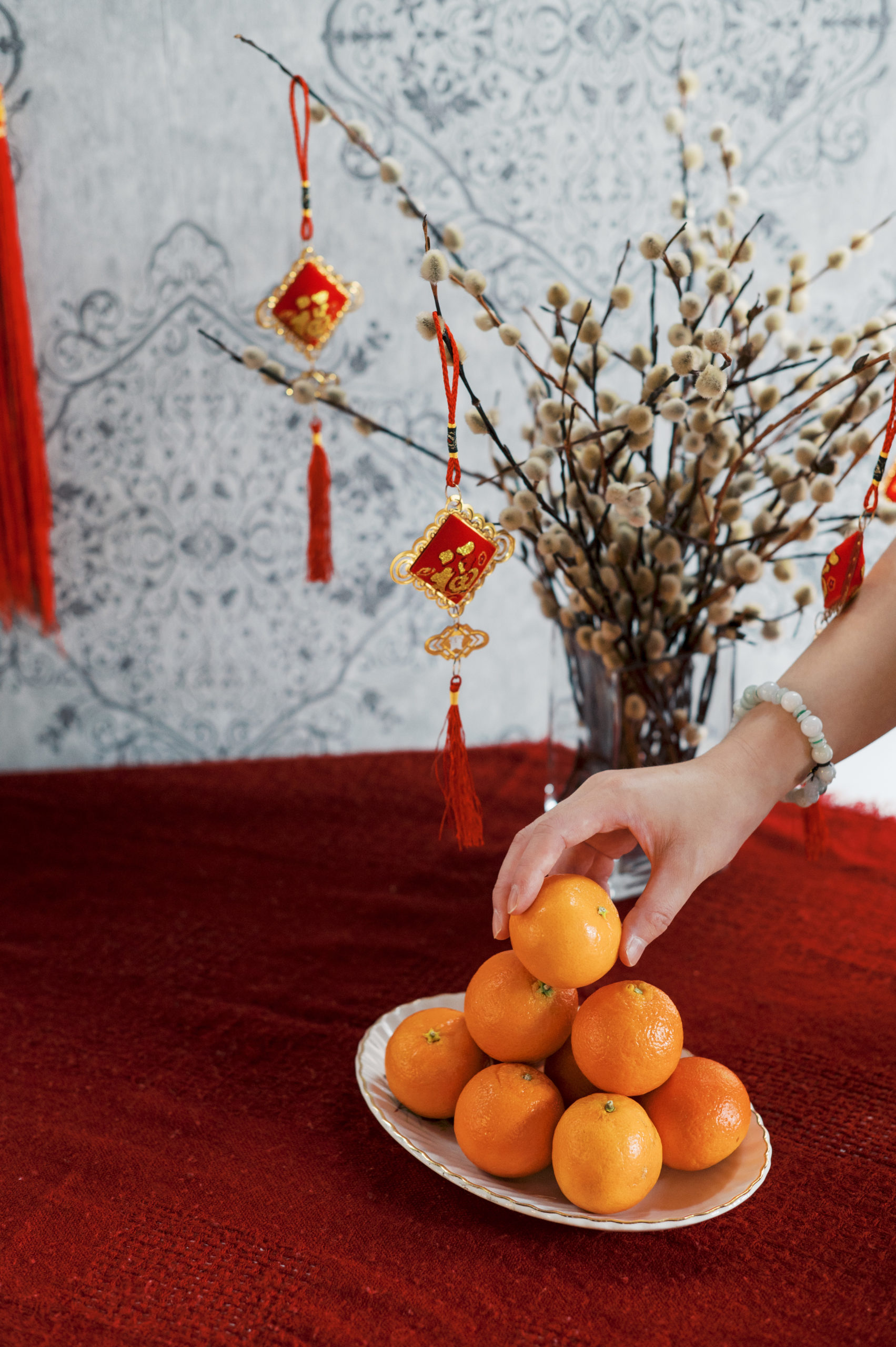 Woman placing orange on orange pile for Chinese New Years